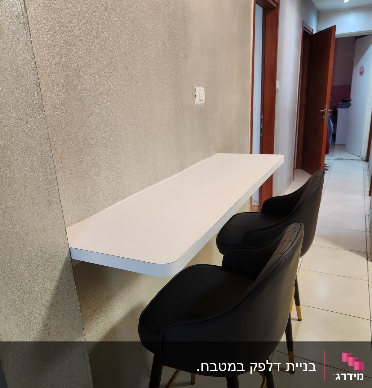 דלפק לבן עם שני כיסאות בר שחורים במטבח